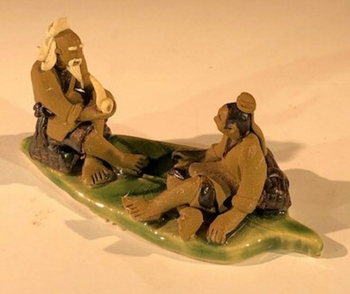 Miniature Ceramic Figurine Two Mud Men On A Leaf, One Sitting Smoking