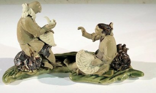 Miniature Ceramic Figurine Two Mud Men On A Leaf, One Sitting Smoking